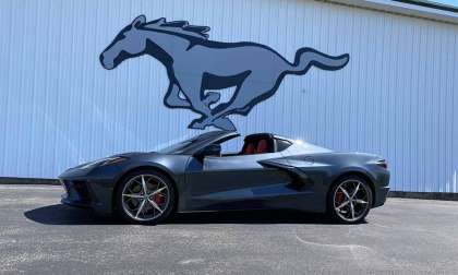 2021 Chevy Corvette in front of Mustang logo