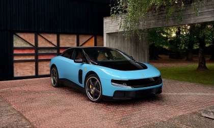Blue Ferrari Luce shown from the front three-quarter angle outside a modern home with trees in the background.