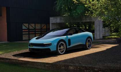 Blue Ferrari Luce parked outside a modern villa in a front three-quarter view.