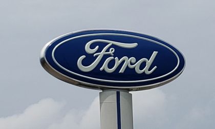 A Ford sign sits high up above a dealership