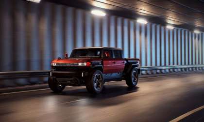 Red GMC Hummer HX truck concept driving through a tunnel in a front three-quarter action view.