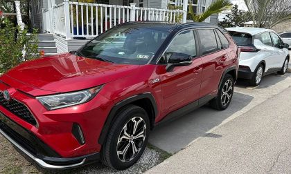 A Toyota RAV4 Prime sits in a warm Florida setting with a Chevy Bolt