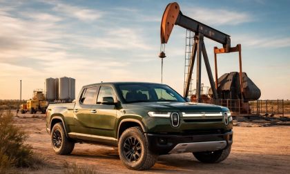 Green Rivian R1T in a west Texas oil field in front of a pump jack