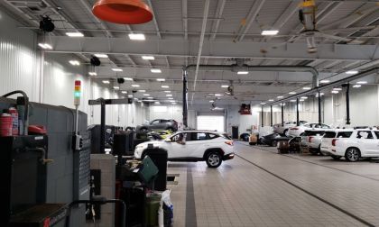 Image shows a Hyundai dealer service area performing repairs on various models