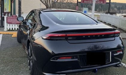 Rear view of a black Honda Prelude parked at a small town street near a gas station