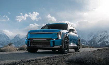Blue Kia EV9 electric SUV parked on a scenic mountain road, showcasing rugged capability, electric SUV design, and outdoor adventure.