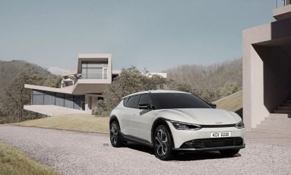 White Kia EV6 electric crossover parked on gravel driveway near modern minimalist home