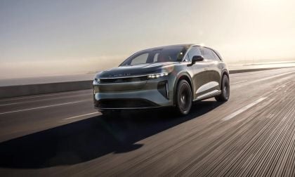 Silver Lucid Gravity electric SUV driving on a highway at sunrise