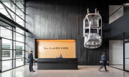 Interior shot of Lucid's California HQ showing a reception desk and wall-mounted Lucid Air body shell.