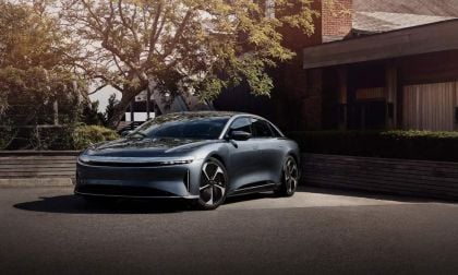 Lucid Pure in Whitney blue captured in motion on desert highway, showcasing sleek luxury sedan profile with aerodynamic design