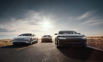 A trio of Lucid Airs in white, red and gold are pictured driving three abreast towards the camera.