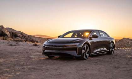 Image of a maroon Lucid Air GT Performance parked in the desert with the setting sun behind the car.