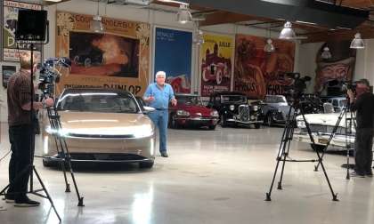 Image showing Jay Leno standing beside a gold Lucid Air during filming for an episode of Jay Leno's Garage