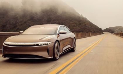 Image showing a gold Lucid Air Dream Edition driving on a mountain road.
