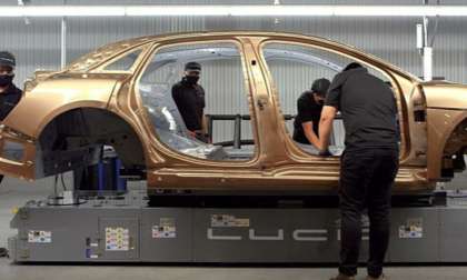 A Eureka Gold Lucid Air Dream Edition is pictured surrounded by workers early in the production process.