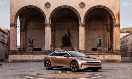 Image of a gold Lucid Air Dream Edition parked in front of a historic building ahead of the brand's first European Studio opening in Munich.