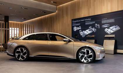 Image showing a gold Lucid Air parked inside the brand's newest Studio in Newport, California