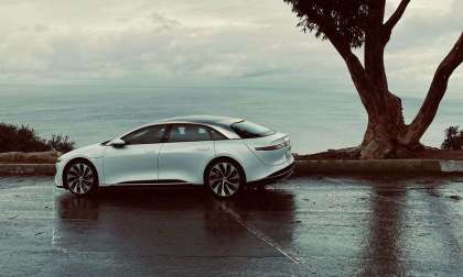 Image of a white Lucid Air parked on a Californian hilltop on a rainy day.