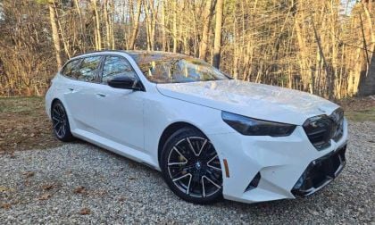 2025 BMW M5 Touring wagon set against a forest backdrop
