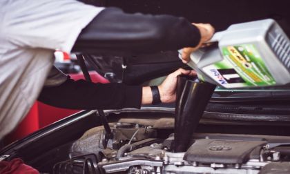 Mechanic Pouring Engine Oil Into A Toyota Prius