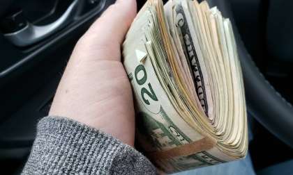 A car shopper holds a bunch of money