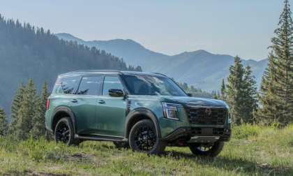 Black Nissan Armada SUV parked on a desert trail, straight-on front view with mountains in the background