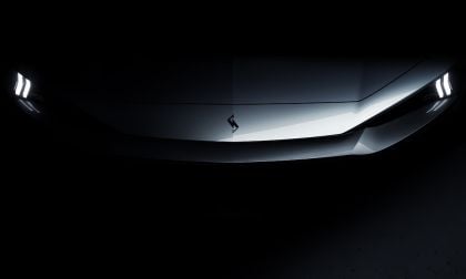 Dark teaser image of new Nissan Skyline concept revealing front fascia with angular LED headlights and lightning bolt hood emblem against black background