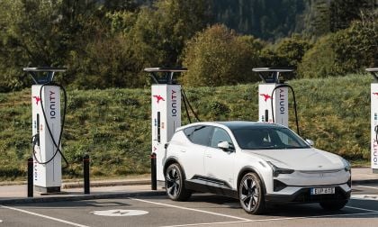  White Polestar 3 electric SUV charging at Ionity 800-volt fast charging station with multiple chargers and forest backdrop