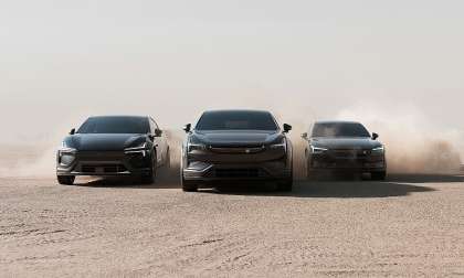 Three Polestar electric vehicles driving through a dusty landscape.