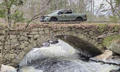 2026 Honda Ridgeline shown crossing a stone arch bridge