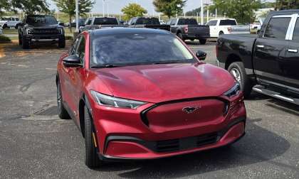 Shawn’s red Ford Mustang Mach-E parked outside a dealership, highlighting its sporty EV styling.