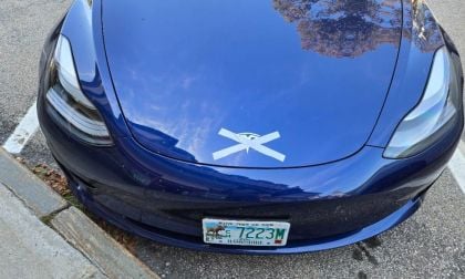 A Tesla is shown with duct tape crossing out its logo as a protest