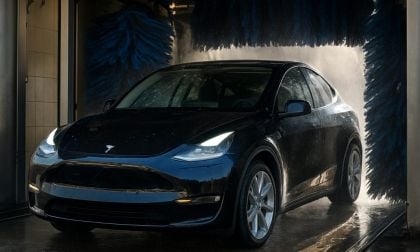 A Tesla Model Y exits a car wash tunnel looking sparkly clean