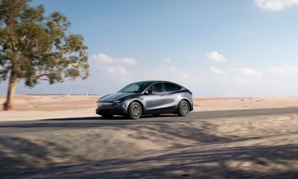White Tesla Model Y electric crossover driving on a highway