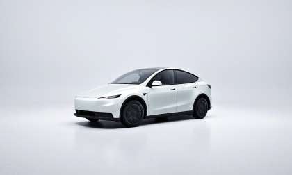 White Tesla Model Y shown in a minimalist studio setting from a front-side angle.