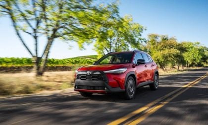 2026 Toyota Corolla Cross in Soul Red Crystal captured in motion on highway, demonstrating dynamic performance and sleek aerodynamic profile