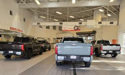 Toyota Tundras line up to enter a Toyota dealer service area