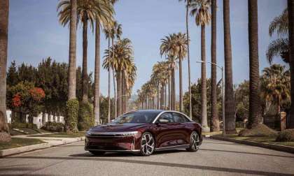 Image showing a Zenith Red Lucid Air Dream Edition parked between rows of palm trees before its Oscars debut.