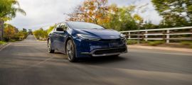 Blue Toyota Prius driving on a suburban road, highlighting its aerodynamic design and hybrid efficiency.