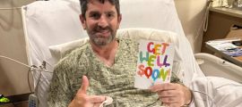 Jack's dad in a hospital bed smiles, holding a colorful "Get Well Soon" card. He gives a thumbs-up with his other hand. The mood is positive and hopeful.