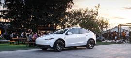 Tesla Model Y electric SUV parked at an outdoor event with people in the background