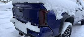 Toyota Tacoma pickup truck with tailgate frozen shut and covered in snow during winter