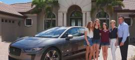 A family stands next to a Jaguar