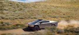 Tesla Cybertruck driving fast on a dusty off-road trail through rolling hills under a cloudy sky.
