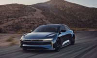 2023 Lucid Air Sapphire high-performance electric sedan in blue driving on a desert road, front three-quarter perspective.