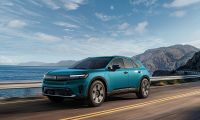 2024 Honda Prologue Elite electric SUV driving along a coastal highway