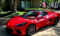 Red 2024 Chevrolet Corvette C8 parked in a residential driveway, showcasing mid-engine sports car design and exterior styling.