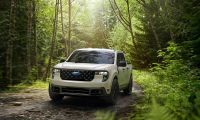 2025 Ford Maverick compact pickup driving on a forest trail, front three-quarter view