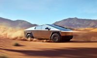 A silver Tesla Cybertruck shown from a side three-quarter view, kicking up dust while driving through a desert landscape with mountains in the background.