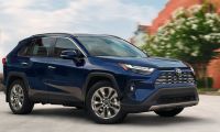 A 2025 Toyota RAV4 in blue metallic paint photographed from the front three-quarter view, emphasizing its athletic stance and contemporary design.